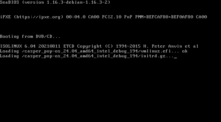 Layar teks putih di atas hitam berisi Booting from DVD/CD dan ISOLINUX 6.04 memuat berkas casper_pop-os_24.04_amd64_intel_debug vmlinuz.efi dan initrd.gz
