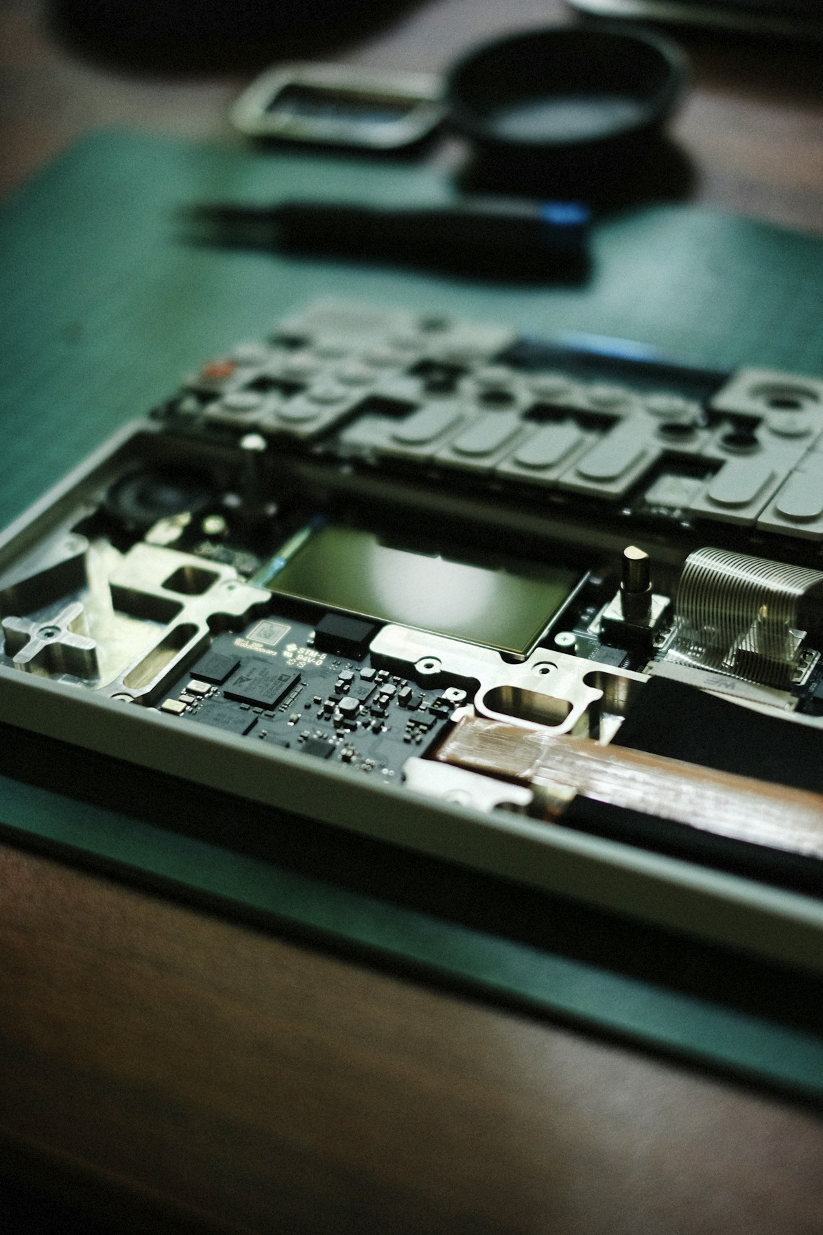 Laptop terbongkar dengan alat servis di sekitarnya