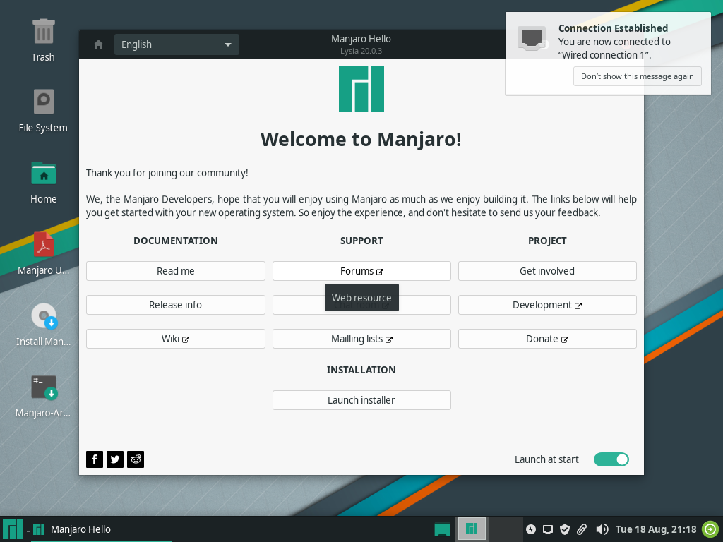 Aplikasi Manjaro Hello menyambut pengguna dengan tombol Launch Installer, sementara notifikasi Connection Established memberi tahu jaringan sudah tersambung otomatis
