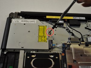 Langkah 2 — Lepaskan Sekrup Penahan Optical Drive