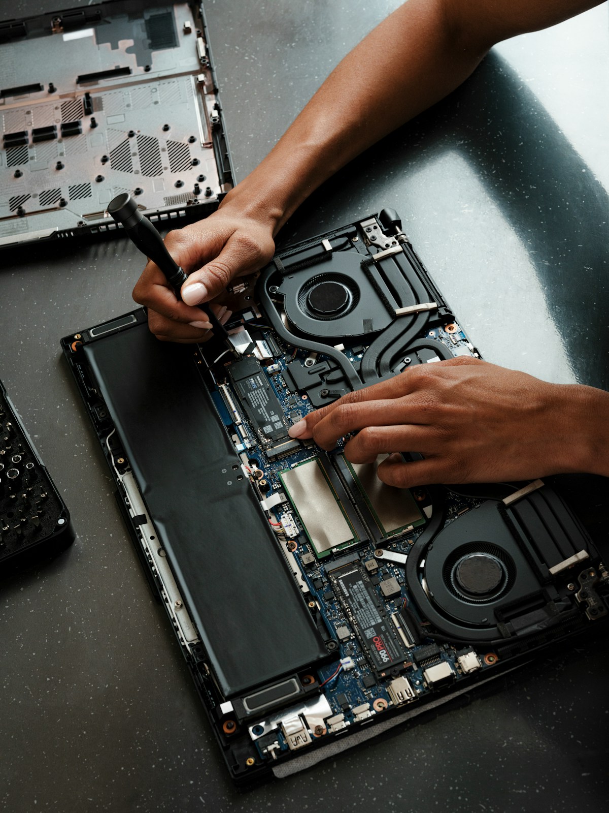 Teknisi memperbaiki laptop yang dibuka untuk servis