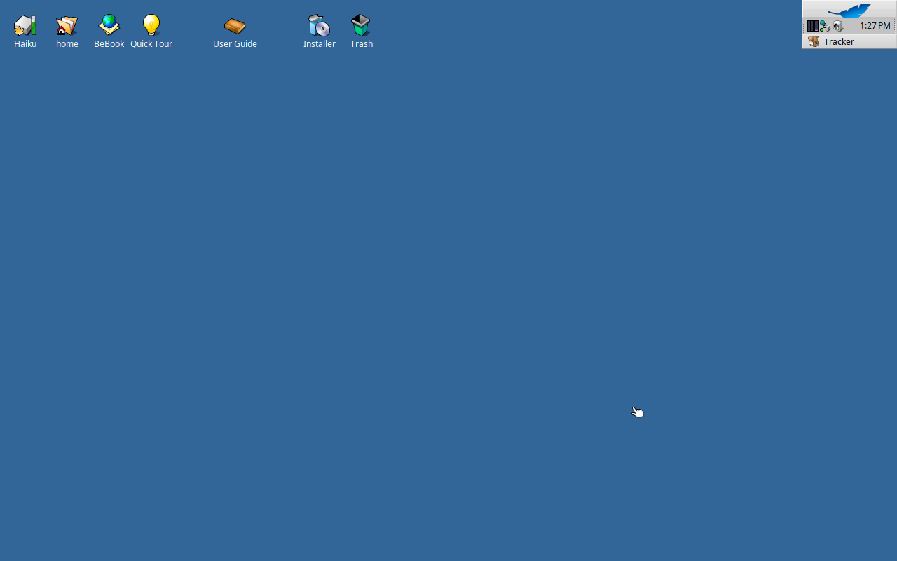 Desktop Haiku dengan latar biru polos, deretan ikon Haiku, home, BeBook, Quick Tour, User Guide, Installer, dan Trash di kiri atas, serta Deskbar berisi jam dan menu Tracker di kanan atas