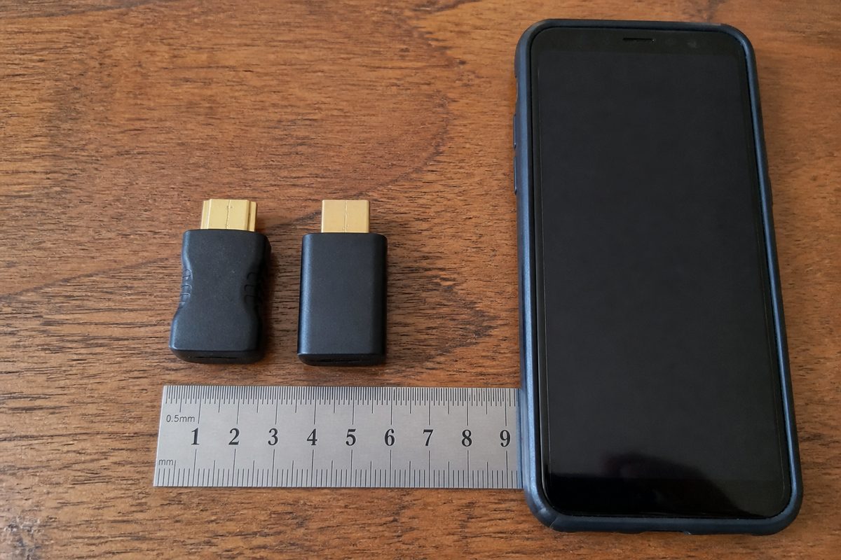 Perbandingan ukuran HDMI dummy plug dengan penggaris dan smartphone