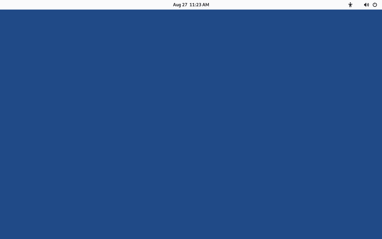 Layar biru polos dengan bilah atas berisi jam dan ikon aksesibilitas, suara, serta daya, muncul sesaat sebelum jendela sambutan Tails tampil