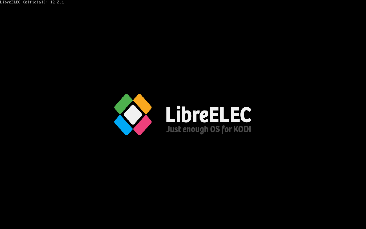 Layar splash boot LibreELEC dengan logo diamond empat warna dan tulisan Just enough OS for KODI di atas latar hitam