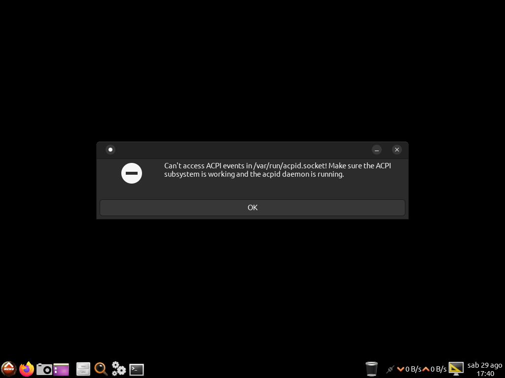 Layar hampir seluruhnya hitam dengan panel taskbar CAINE di bagian bawah dan sebuah kotak dialog galat berisi pesan Can t access ACPI events in var run acpid.socket